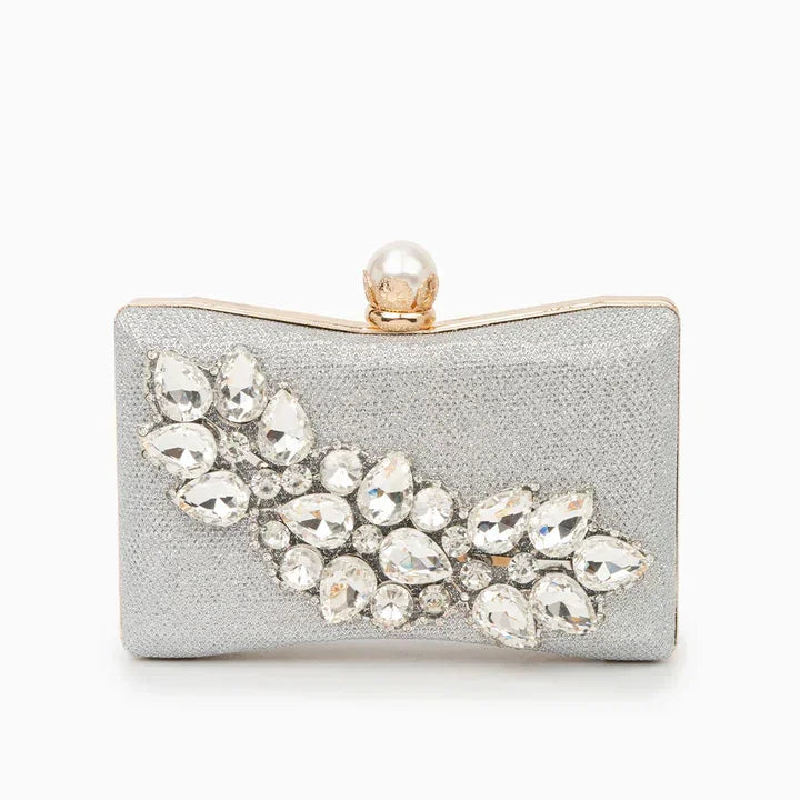 Silver clutch purse with crystal embellishments and pearl clasp on white background
