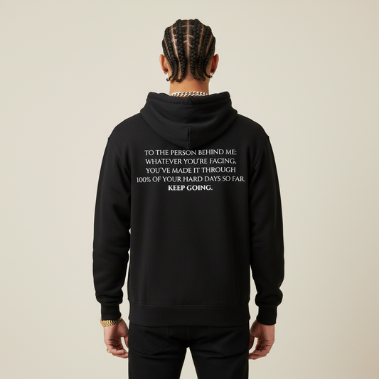Black hoodie with motivational text on the back against a light gray background