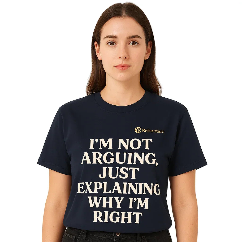 Person wearing a navy blue t-shirt with humorous text on a beige background