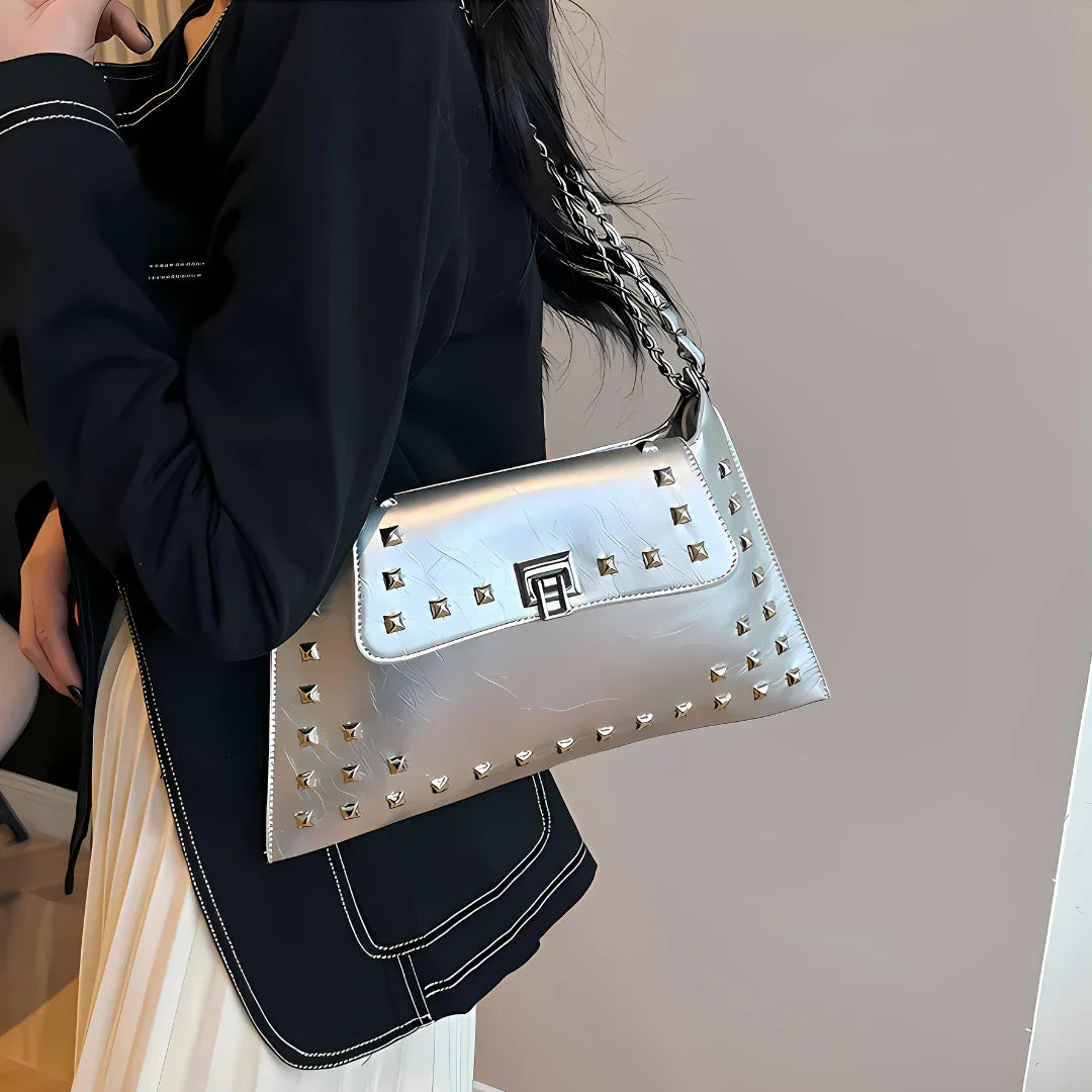 Woman wearing a stylish silver studded shoulder bag with chain strap