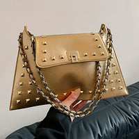 Gold studded handbag with chain strap, pyramid studs, and textured leather finish