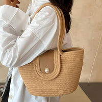 Woman in white shirt with beige woven handbag and pearl button accent