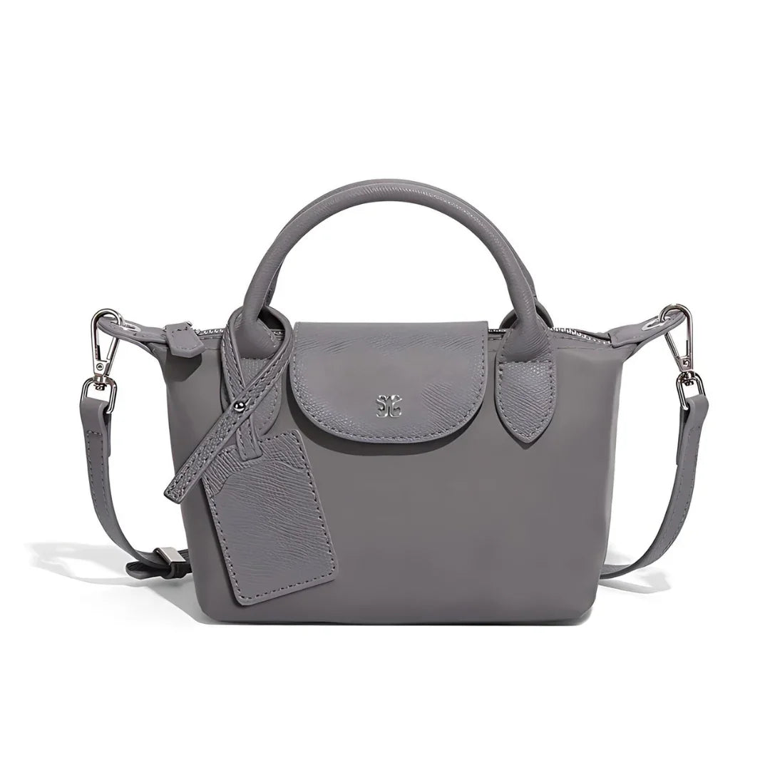 Gray leather crossbody handbag with top handles and detachable shoulder strap on white background