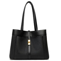 Black leather tote bag with gold buckle and double handles on white background