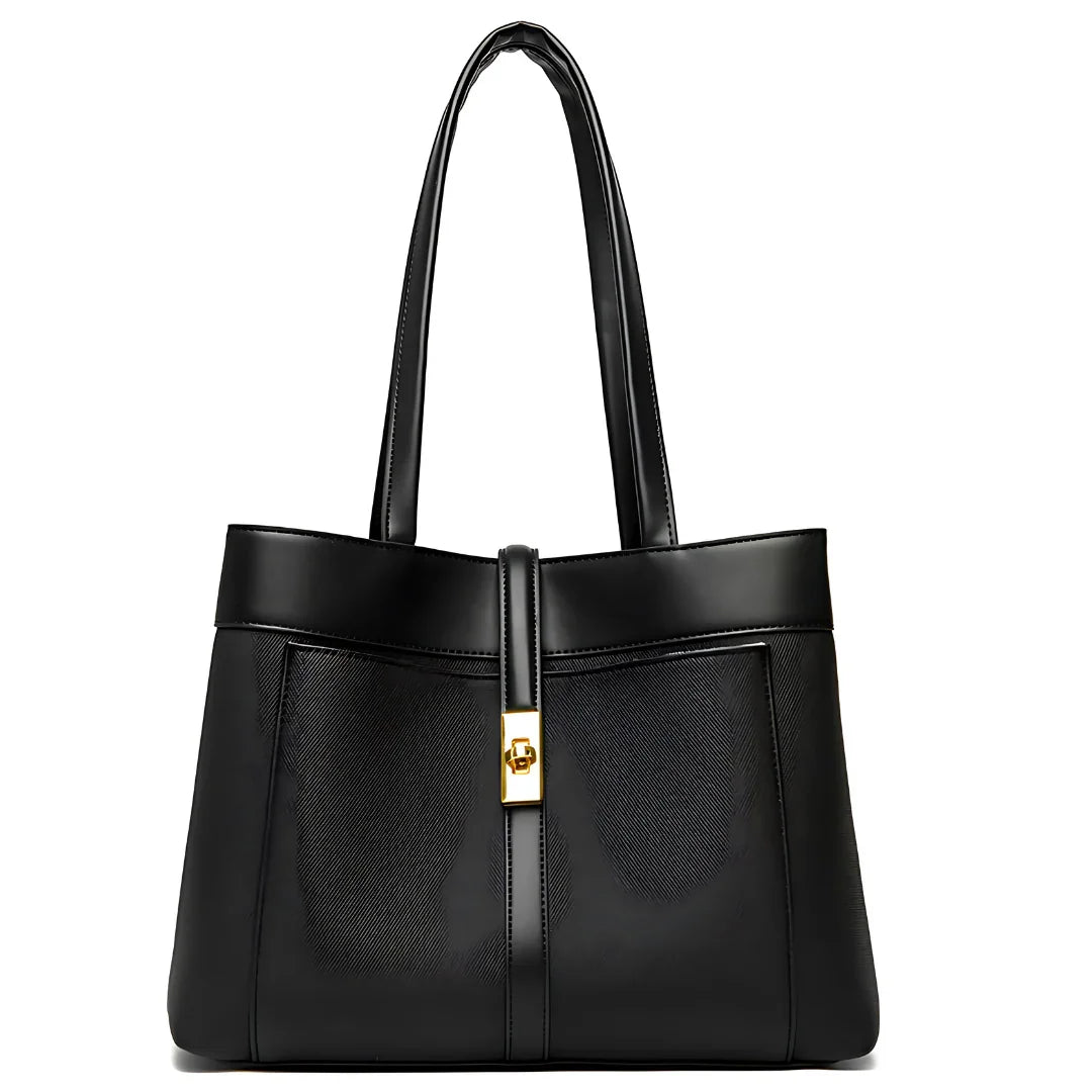 Black leather tote bag with gold buckle and double handles on white background
