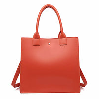 Red square leather tote bag with double handles and minimalist design