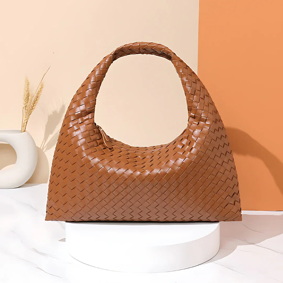 Brown woven leather hobo handbag on white display with modern minimalist background