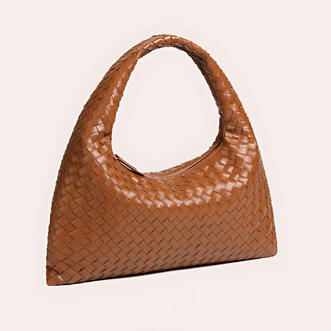 Brown woven leather hobo bag with a wide handle on a light background