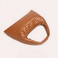 Brown woven leather hobo bag with single handle on light background