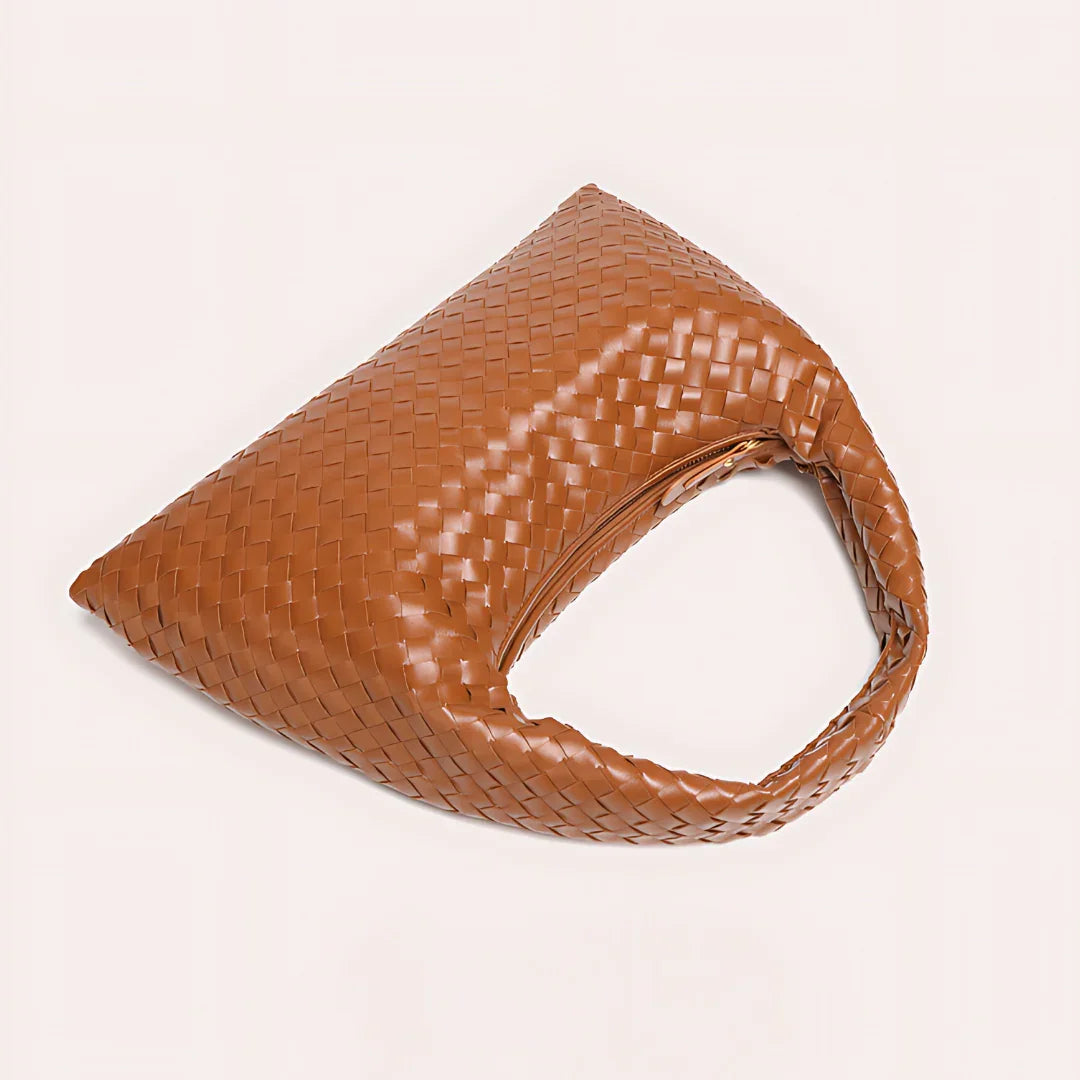 Brown woven leather hobo bag with single handle on light background