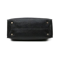 Bottom view of black textured leather handbag with silver metal feet