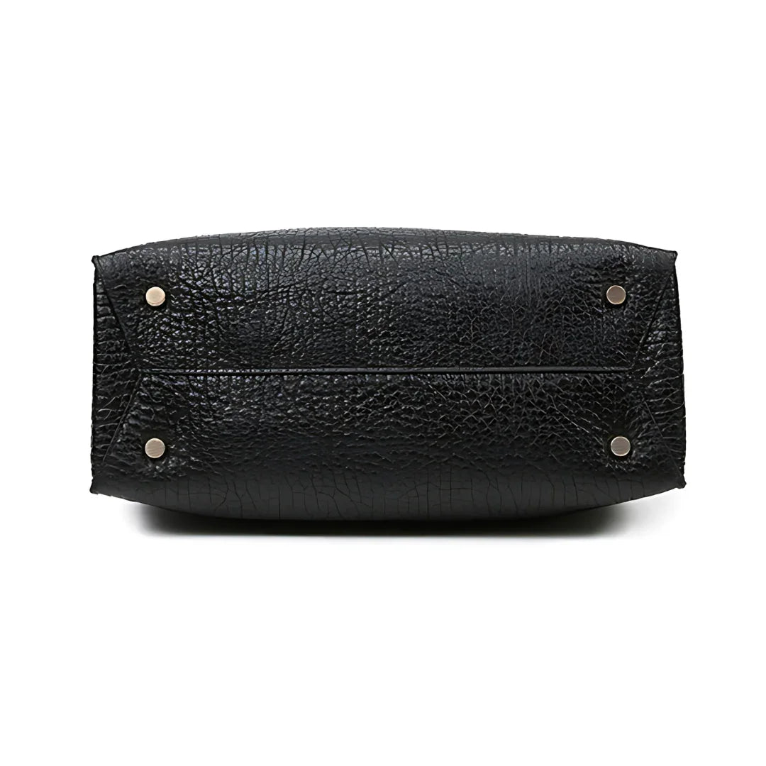 Bottom view of black textured leather handbag with silver metal feet
