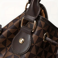Brown geometric patterned handbag with leather trim and gold hardware close-up