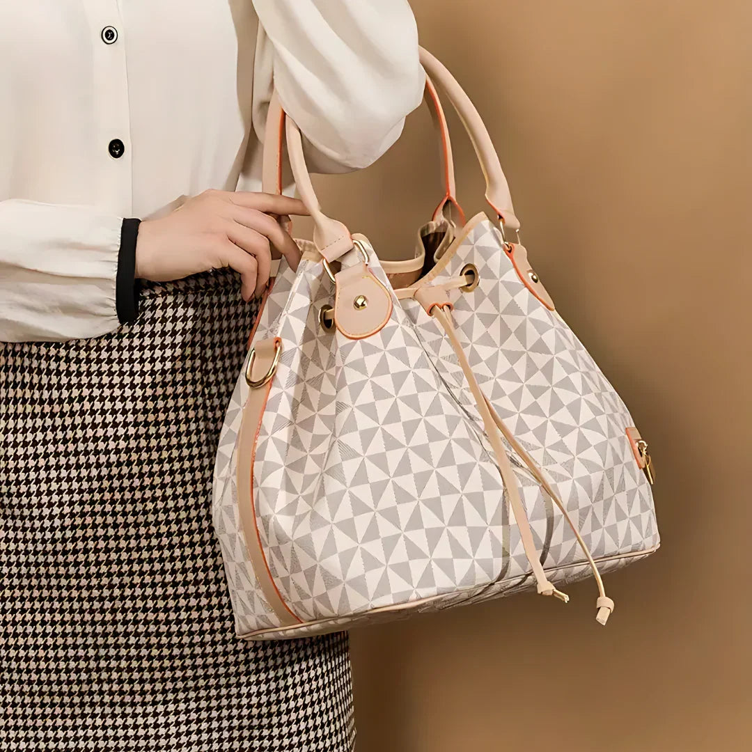 Woman holding geometric patterned bucket bag with beige leather trim
