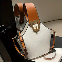 White leather handbag with brown straps and gold buckle on display