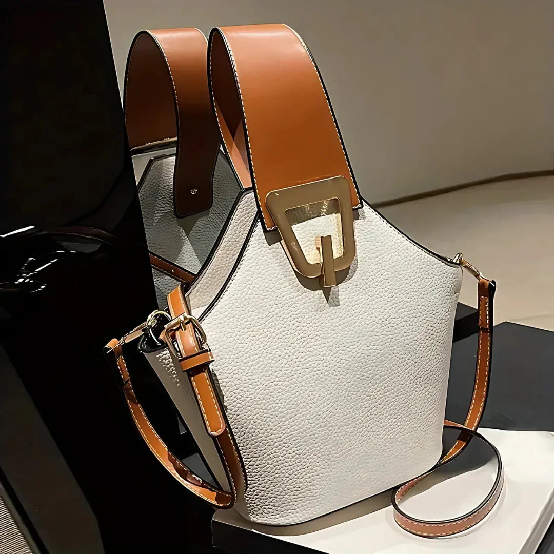 White leather handbag with brown straps and gold buckle on display