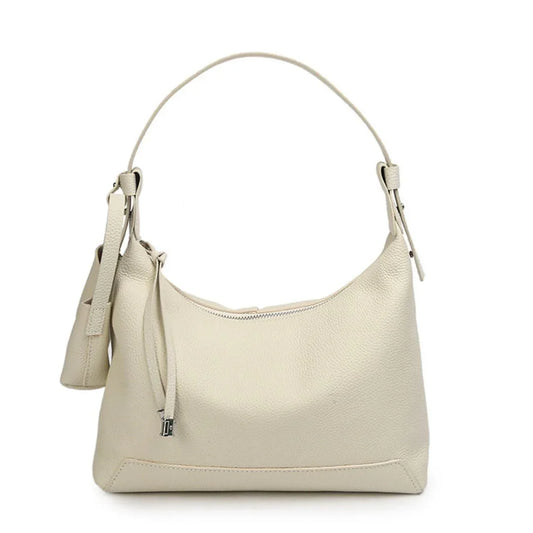 Beige leather shoulder bag with single strap and zip closure on white background