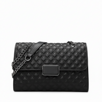 Black quilted leather handbag with chain strap and rectangular metal clasp on white background