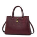 Elegant burgundy leather handbag with gold charm and dual top handles on white background