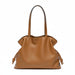 Brown leather tote bag with knotted sides and double handles on a white background