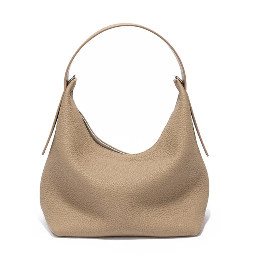 Beige leather hobo bag with single strap, minimalist and textured design on white background