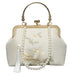 Elegant white floral handbag with gold handle, pearl strap, and tassel accent