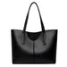 Black leather tote bag with double handles, minimalist and sleek design