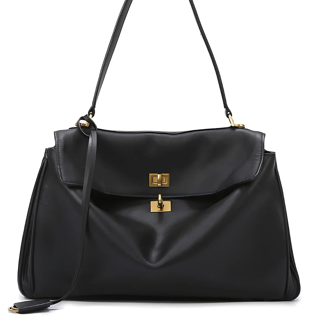 Black leather shoulder bag with gold hardware and top handle on white background