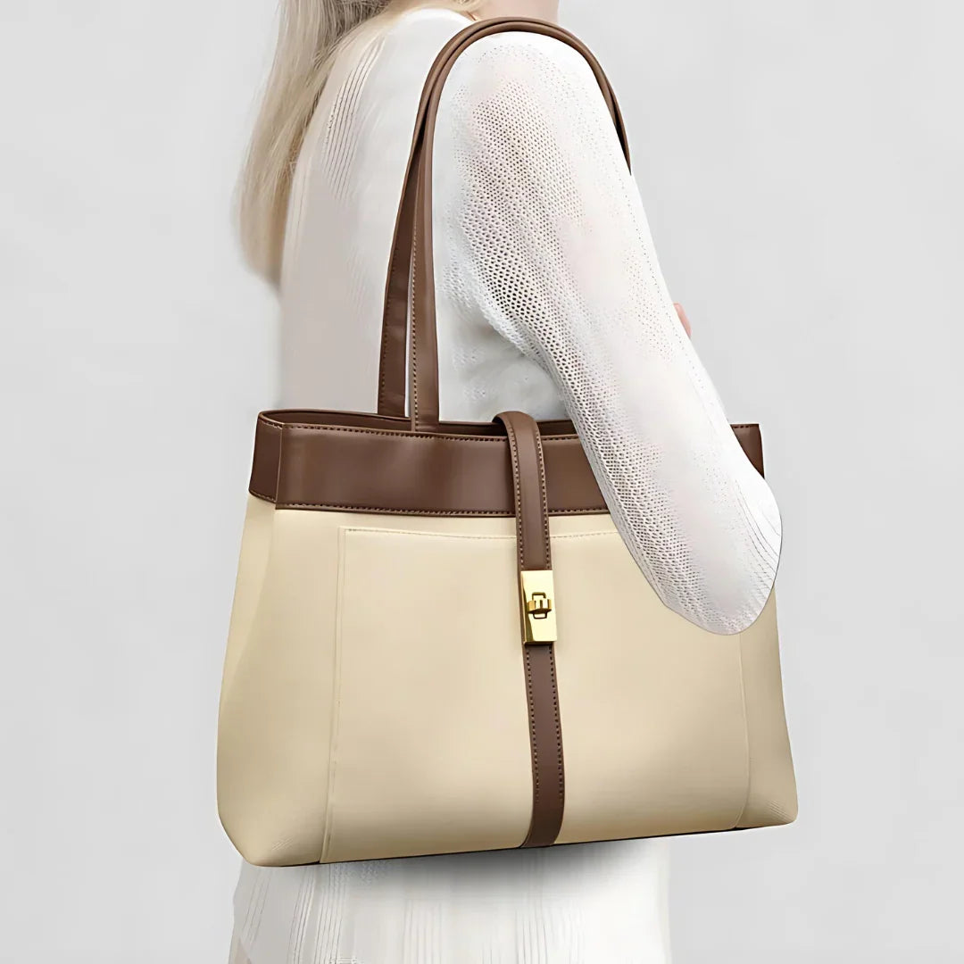 Woman in white dress carrying beige and brown leather tote bag with gold clasp