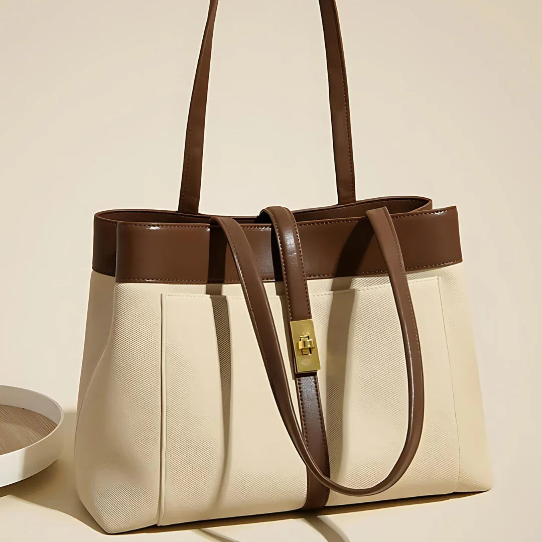 Elegant beige and brown leather tote bag with gold lock detail on neutral background