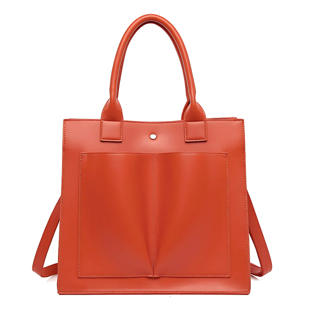 Orange leather tote bag with front pockets and double handles against white background