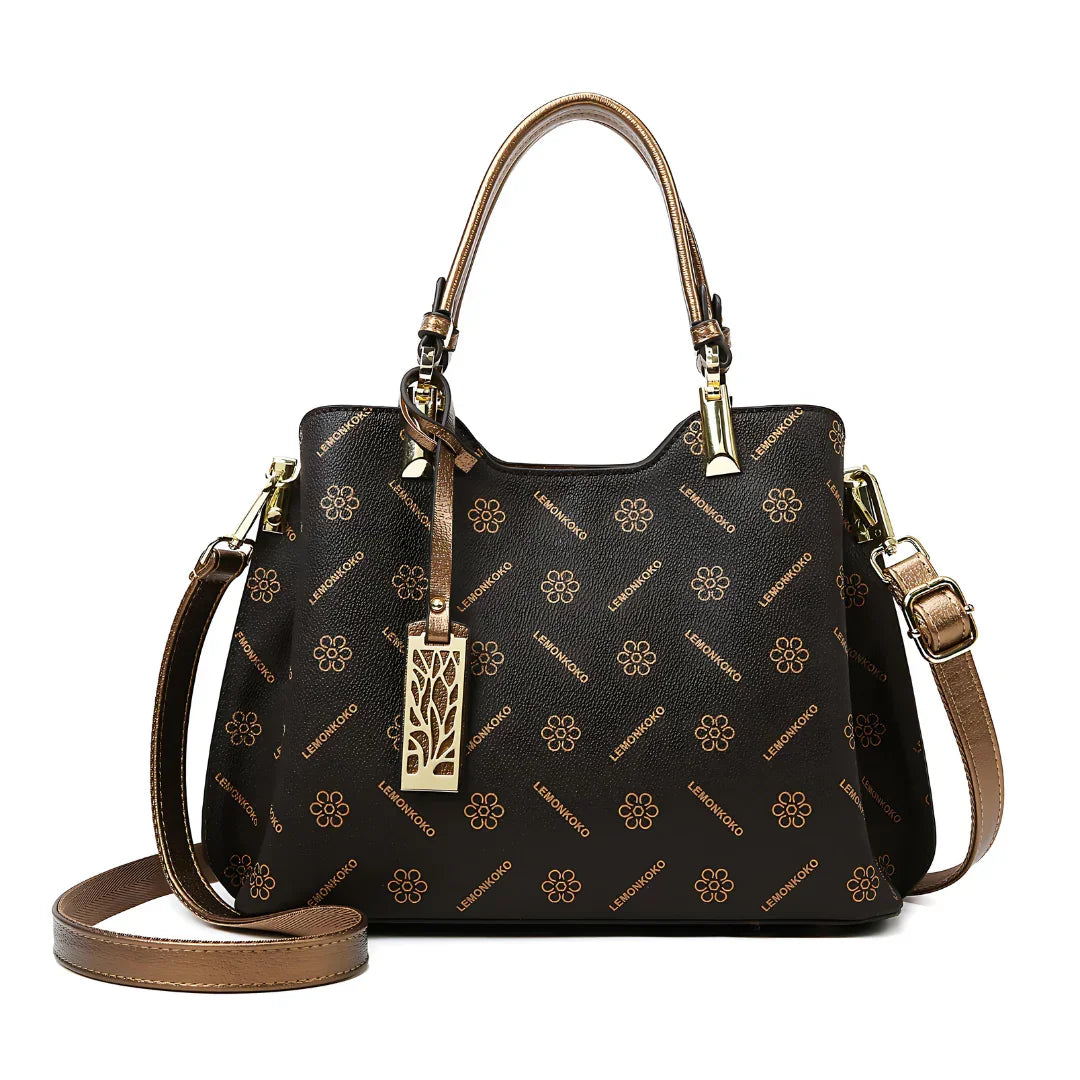 Brown designer handbag with floral pattern, gold hardware, and adjustable strap on white background