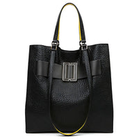 Black textured leather tote bag with wide buckle detail and yellow-lined handles