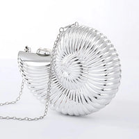 Silver seashell shaped clutch purse with chain on white background