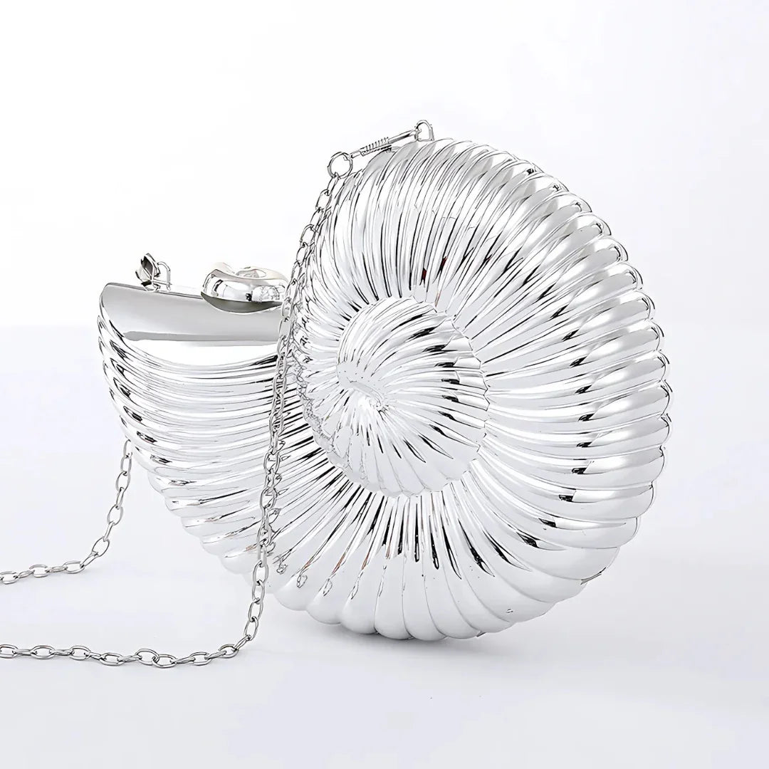 Silver seashell shaped clutch purse with chain on white background