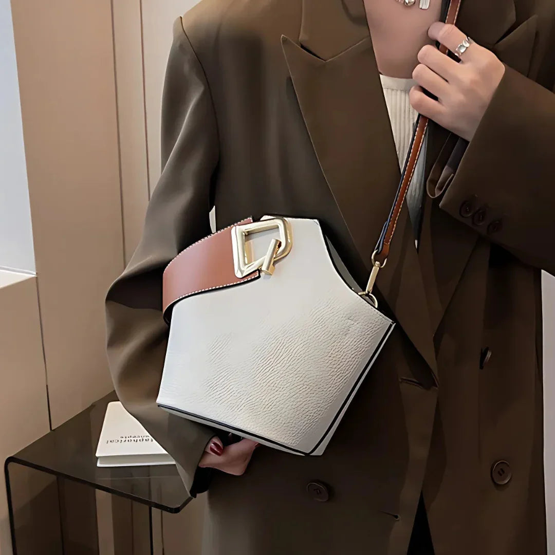 Woman in brown blazer holding modern geometric white and brown handbag with gold buckle