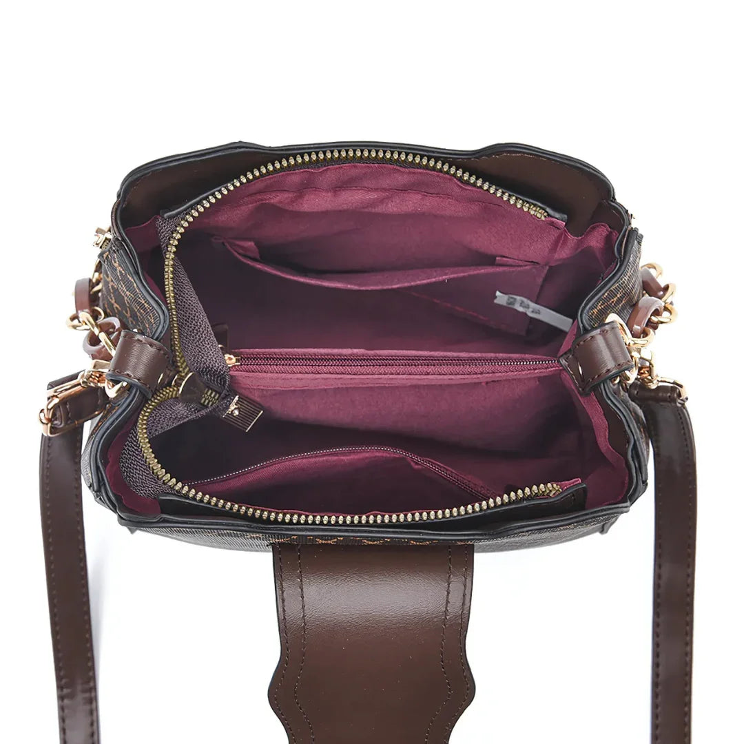 Open brown leather handbag with gold zippers and maroon fabric interior compartments