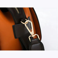 Close-up of gold clasp on brown leather handbag with orange interior