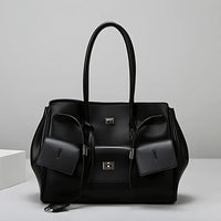 Black leather tote bag with silver hardware on a white background, modern handbag style