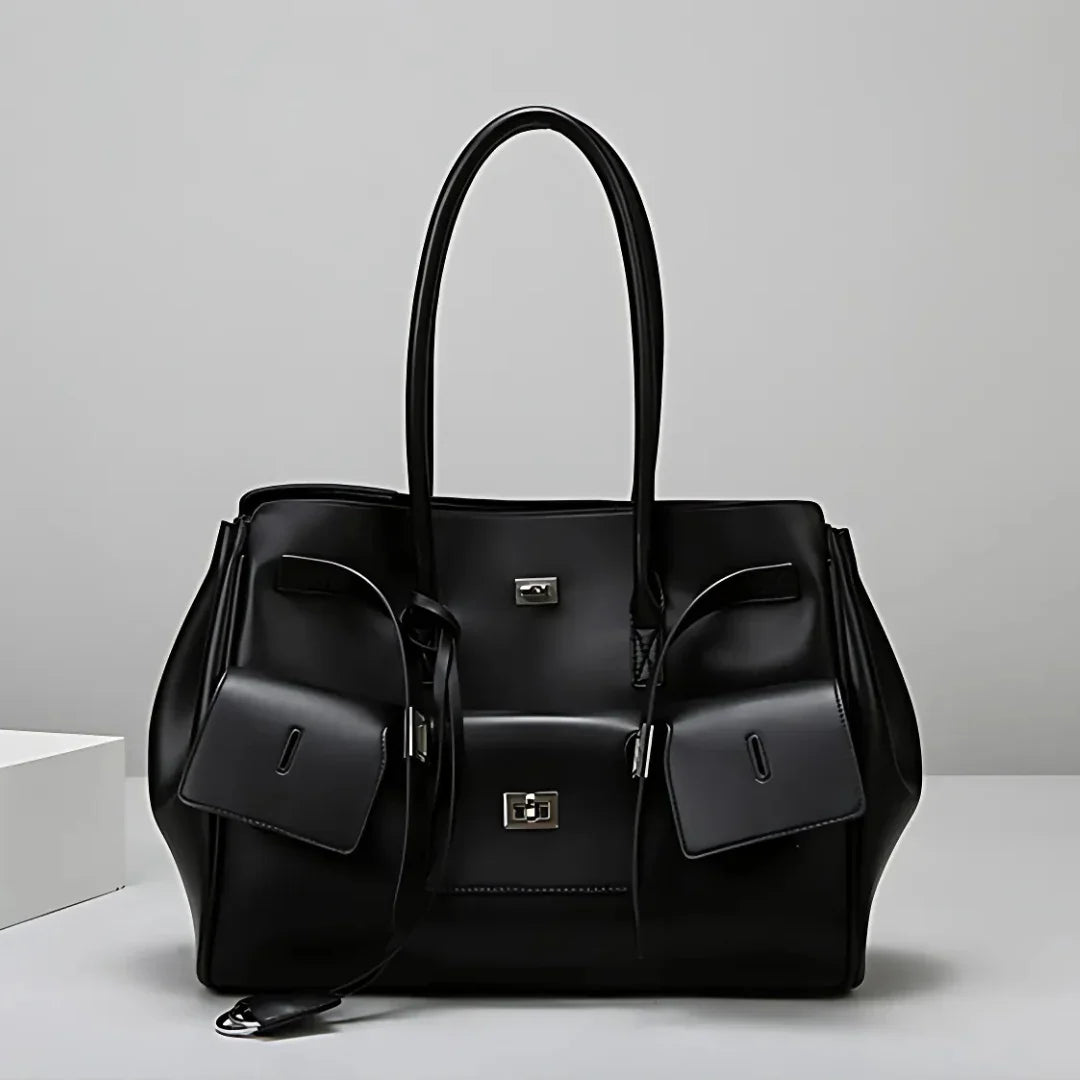 Black leather tote bag with silver hardware on a white background, modern handbag style