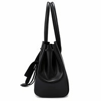 Side view of black leather tote bag with double handles and drawstring detail