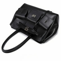 Oversized black leather handbag with long handles, silver hardware, and front pockets