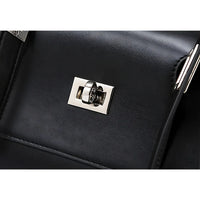 Black leather bag with shiny silver turn-lock clasp close-up