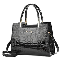 Glossy black crocodile pattern handbag with gold accents and top handles