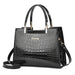 Glossy black crocodile pattern handbag with gold accents and top handles
