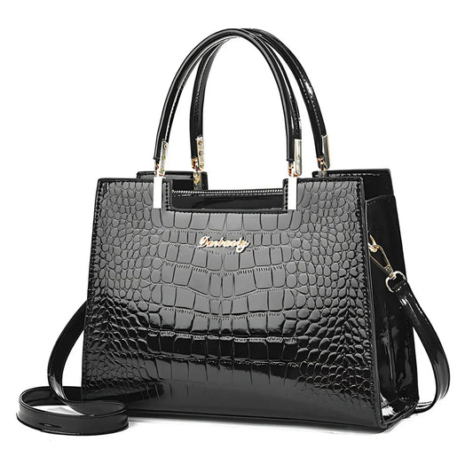 Glossy black crocodile pattern handbag with gold accents and top handles