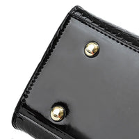 Glossy black purse bottom with gold metal feet, textured edge detail