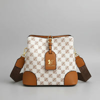 Checkered brown and white crossbody bag with gold hardware and branded tag on grey background
