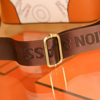 Brown bag strap with gold buckle on orange and white designer handbag