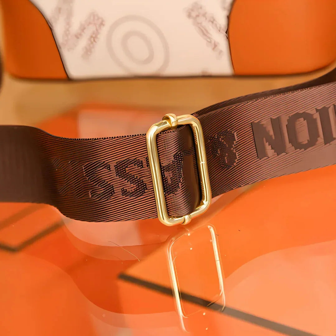 Brown bag strap with gold buckle on orange and white designer handbag